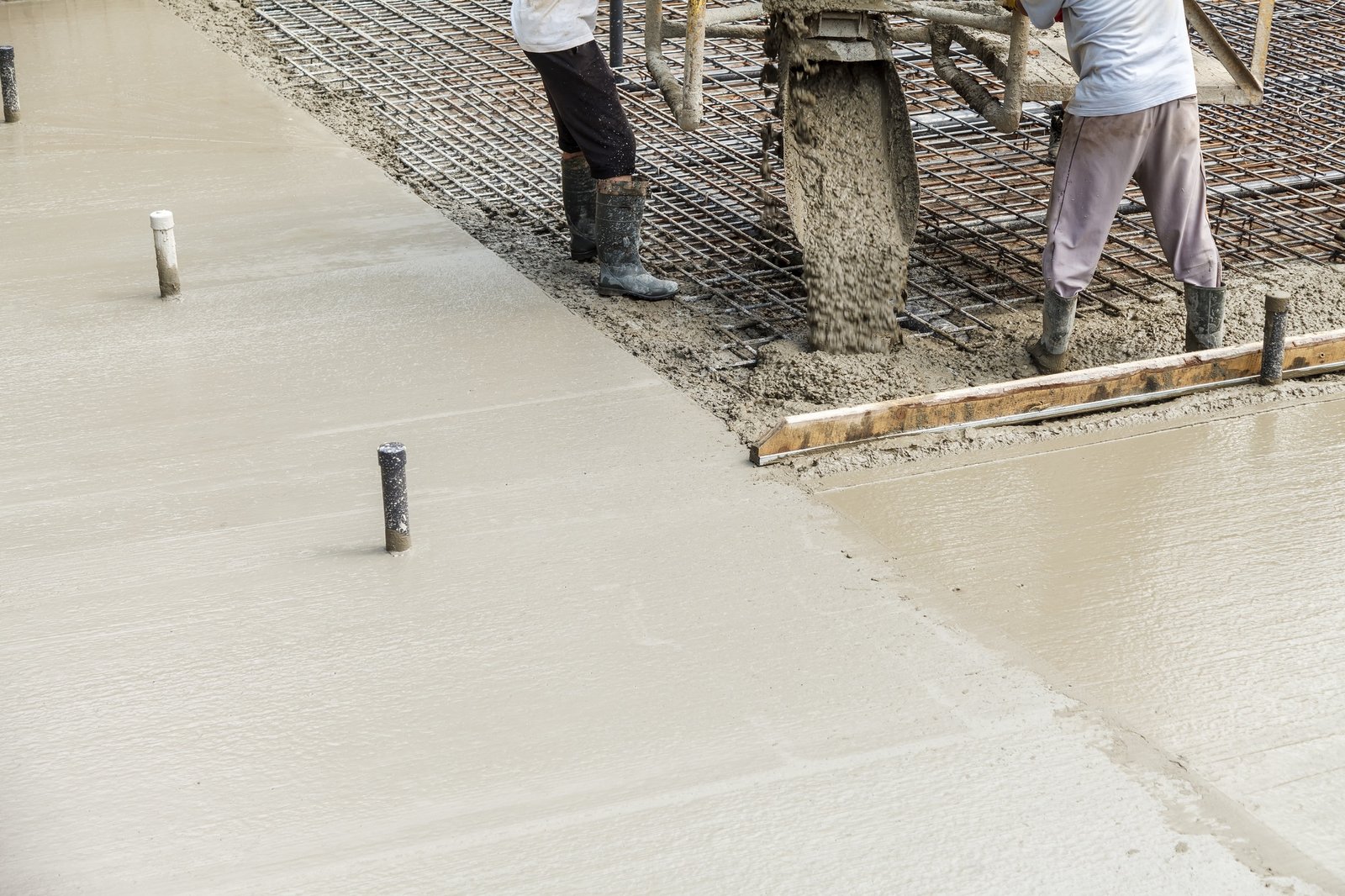 pouring concrete into the construction of the house builders are pouring ready mixed concrete